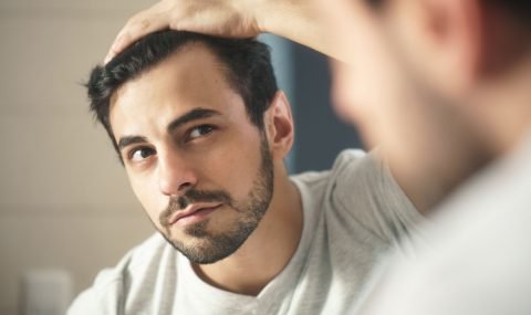 close-up-of-handsome-man-looking-in-mirror-at-home-royalty-free-image-1632864659-2