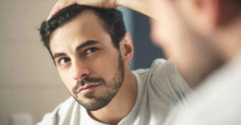 close-up-of-handsome-man-looking-in-mirror-at-home-royalty-free-image-1632864659-2